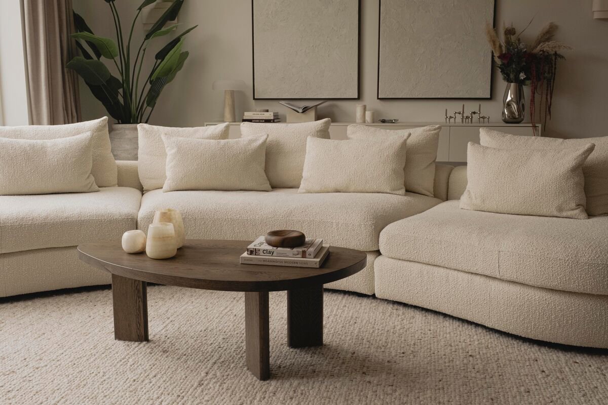 Japandi woonkamer met een ovale zitbank en kiezelvormige salontafel