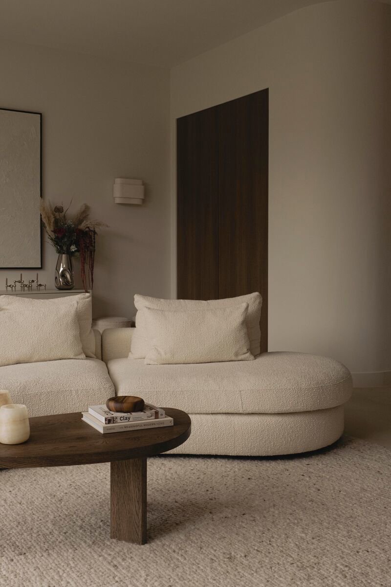 Close up Japandi woonkamer met een lichte bank en donkere eiken salontafel