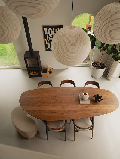 Notenhouten eettafel organische vorm en notenhouten eetkamerstoelen en dinerpoef