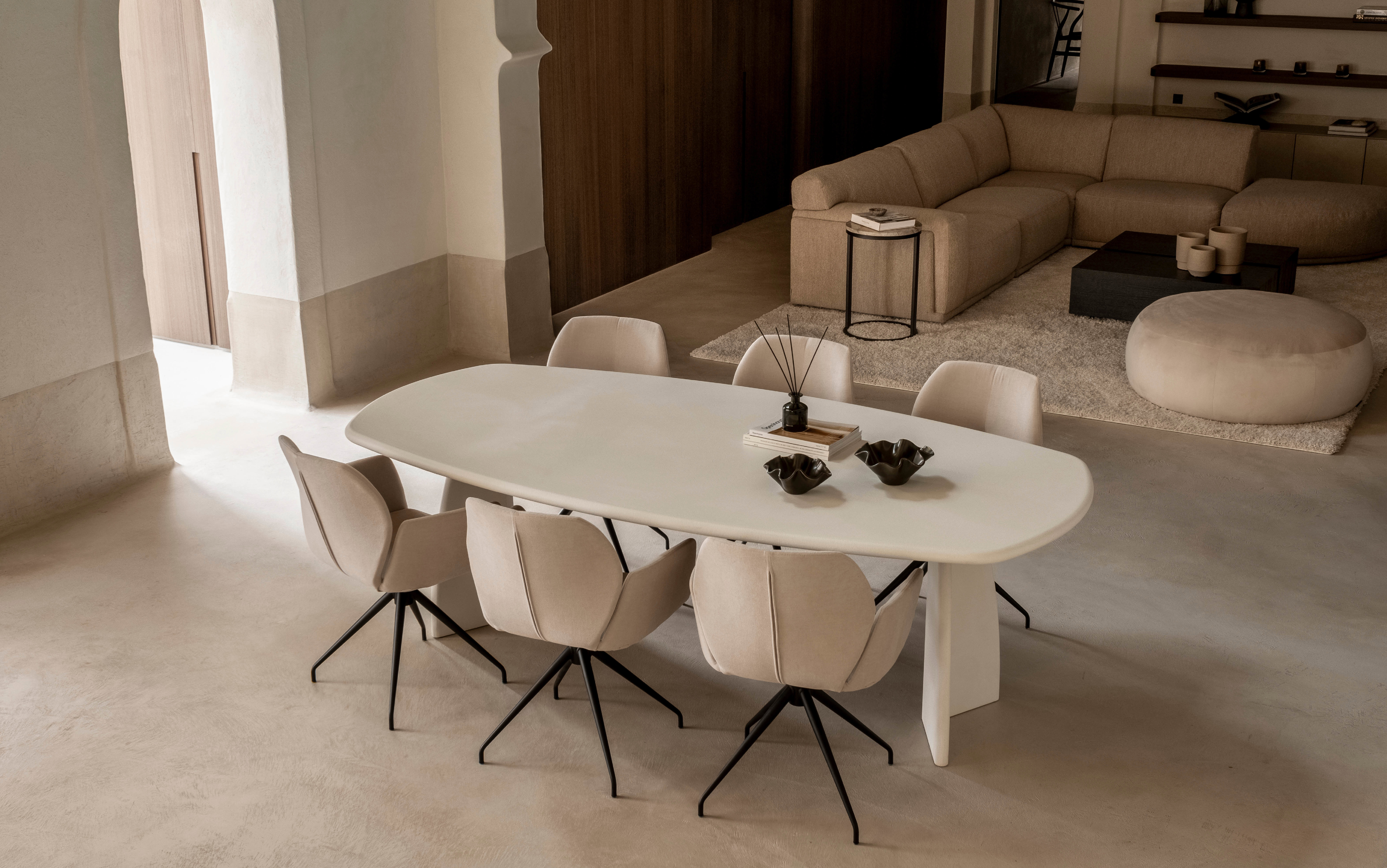 Op deze afbeelding is een ovale eettafel te zien gemaakt van beton, genaamd Conair.