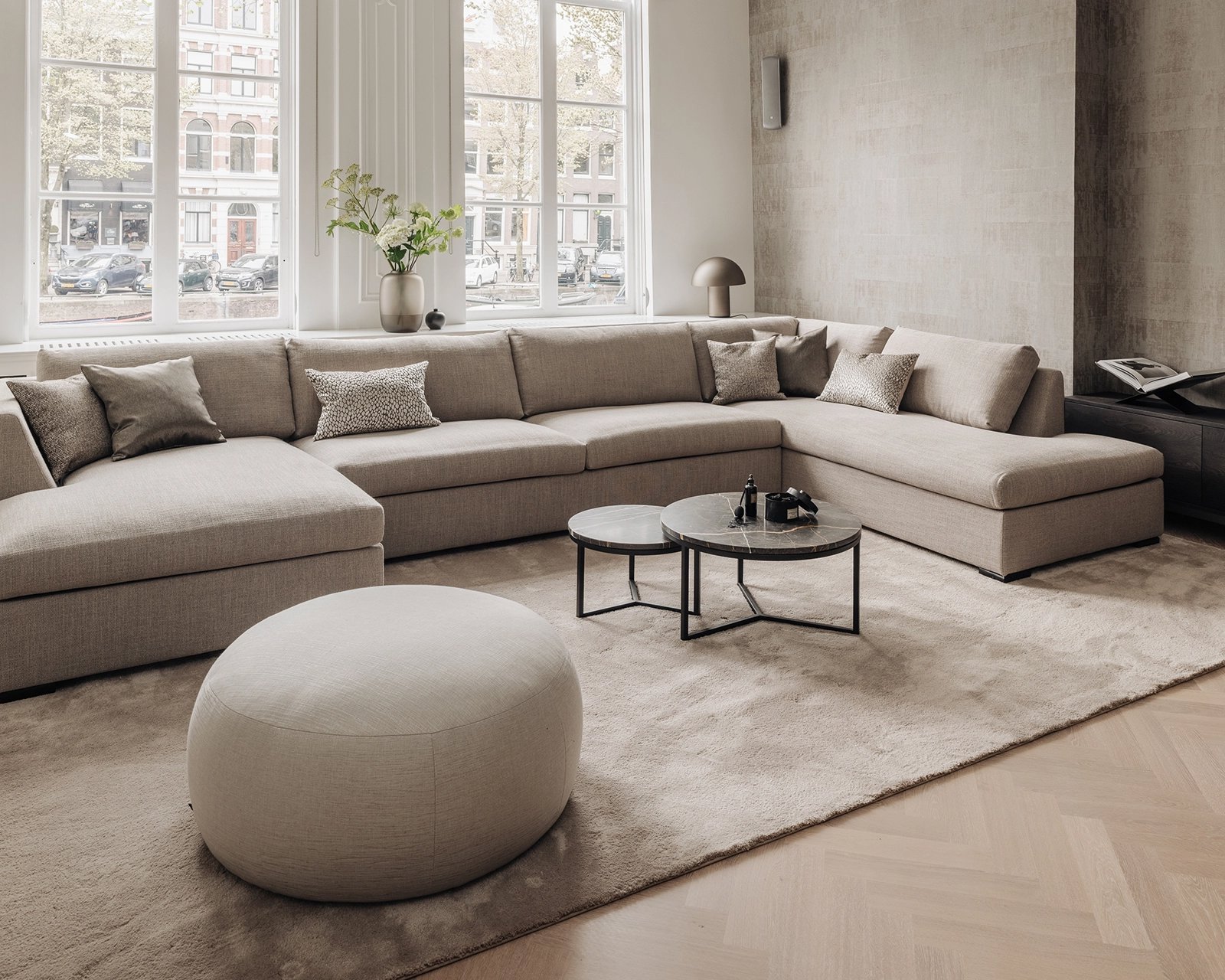 Donna hoekbank met vloerkleed Rubis, 300x470 cm in kleur 34. Marmeren salontafel set Veva. Pastille pouf.