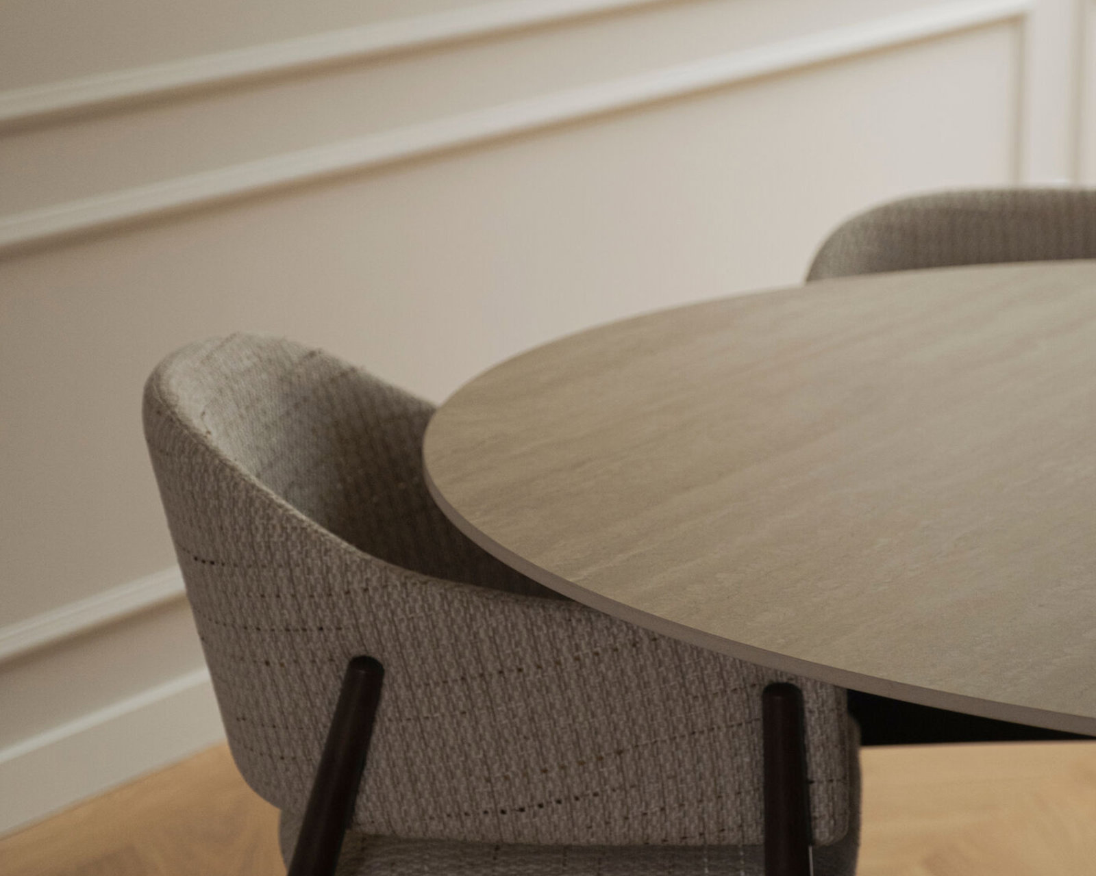 Ronde keramische eettafel Celso met een stoffen eetkamerstoele