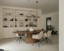 In deze afbeelding is een ovale eettafel te zien gemaakt van notenhout, genaamd Eqone.