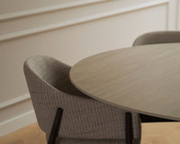 Ronde keramische eettafel Qone oak met een stoffen eetkamerstoel
